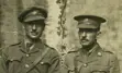 A sepia-toned photograph of two World War I officers in uniform seated side by side, taken in Steenvoorde, France, on August 24, 1916.