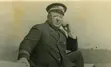 Old image of a white man posing in a sailor outfit.