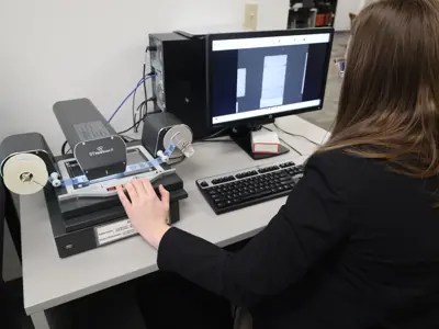 Patron using the microfilm scanner in the reading room.