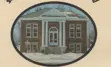 Photo of a red brick building with white pillars in the winter.