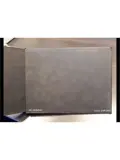 A closed black photo album labeled 4B Clinkman and 2016.067.001 rests on a wooden surface with its cover slightly open.